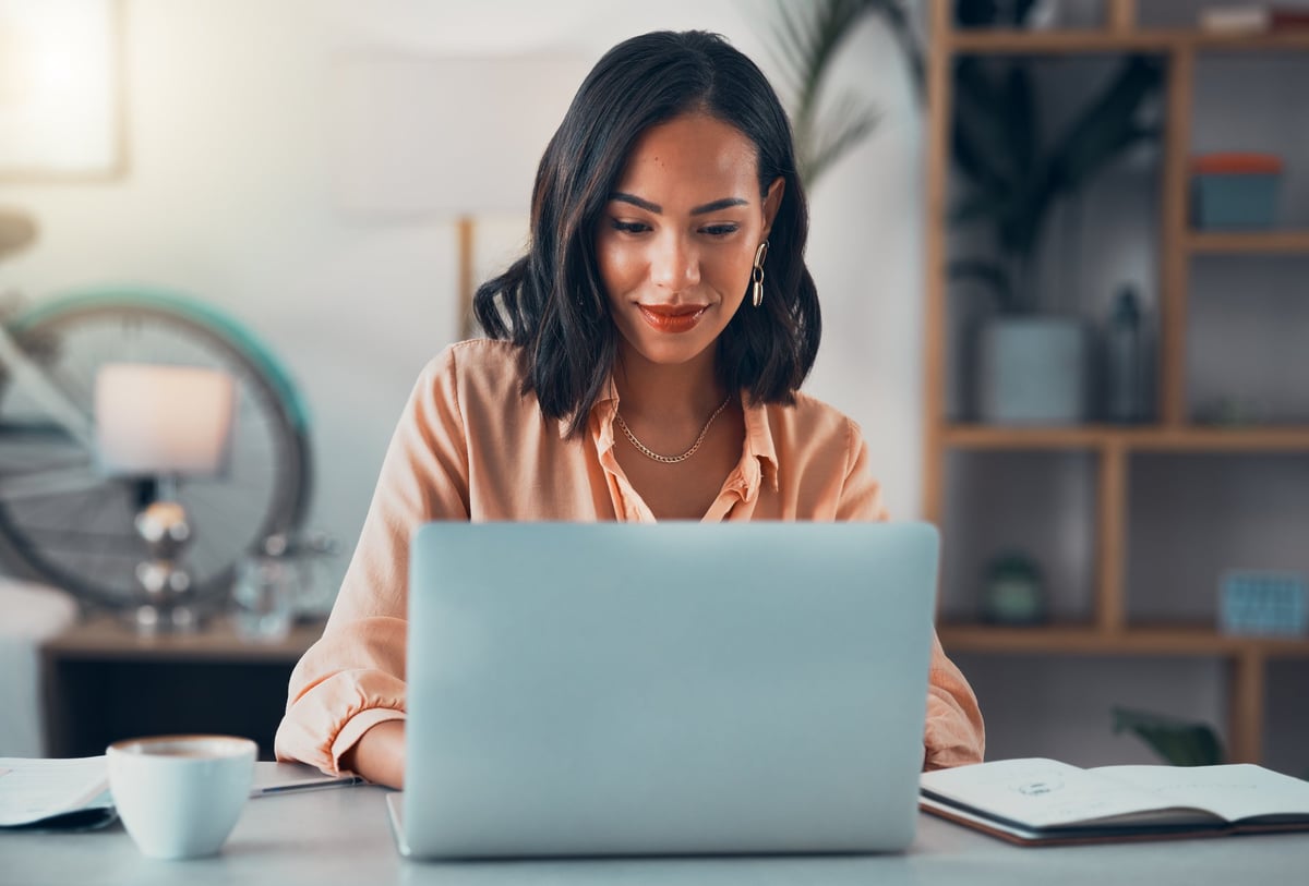 Woman working on laptop online in modern office setting