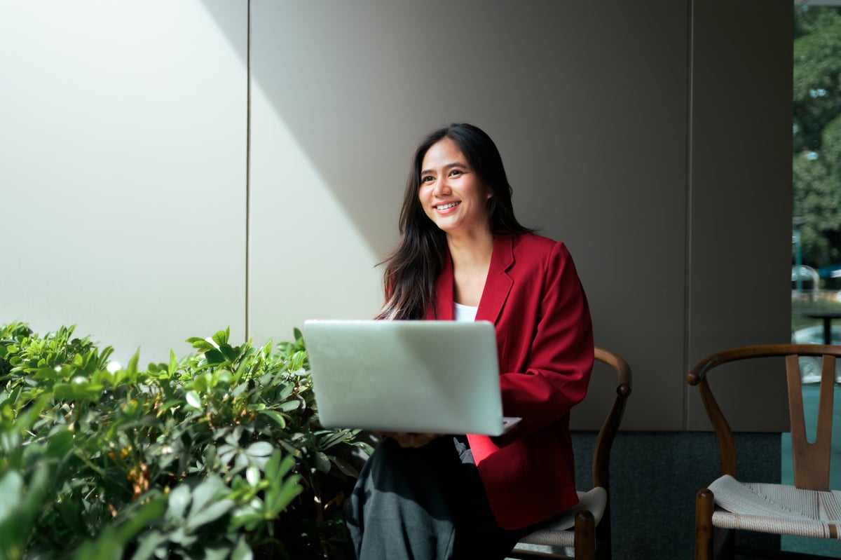 Businesswoman working on laptop outdoors — professional brand content